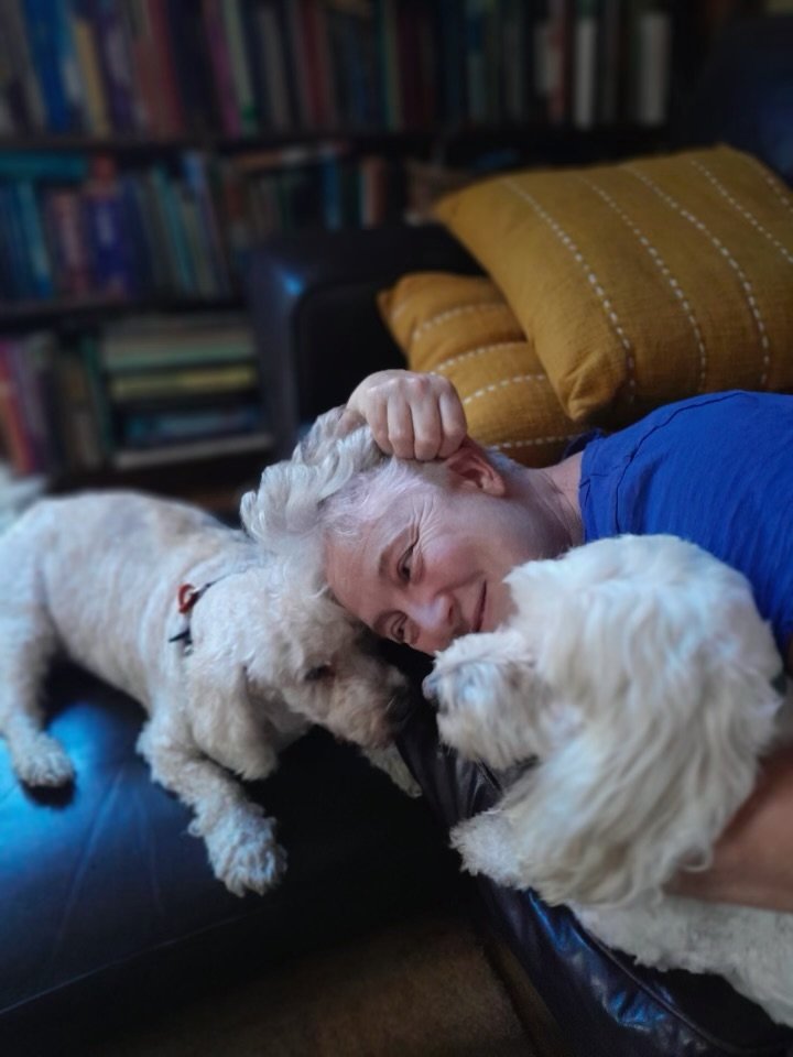 Woman holding on to her two senior dogs with love and compassion